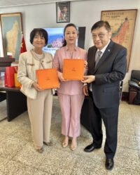 The Ambassador of Madagascar to China, His Excellency Jean Louis Robenson, and his wife give a thumbs up to the Aurora scarf platform