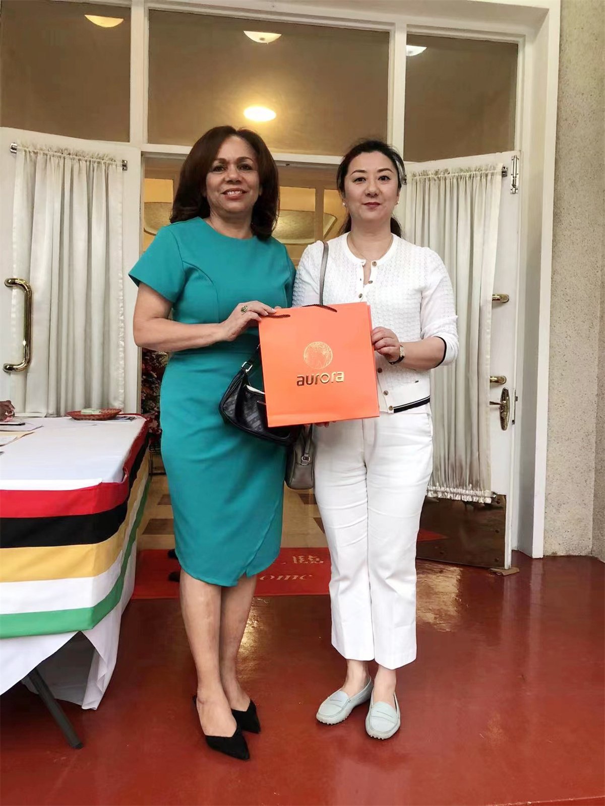 Her Excellency Anne, Ambassador of the Republic of Seychelles to China, stands on the platform for Aurora scarves